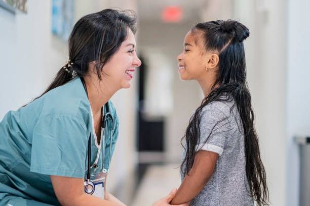 Doctor talking to a little girl stock photo