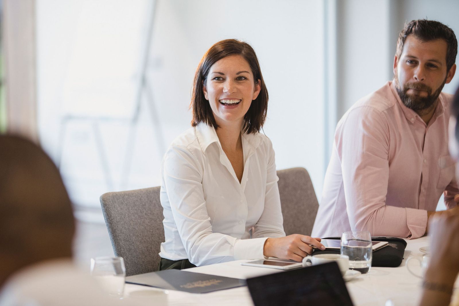 A smiling woman in a discussion with colleagues