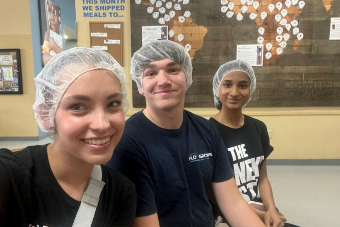 Three people with plastic wrap on their heads